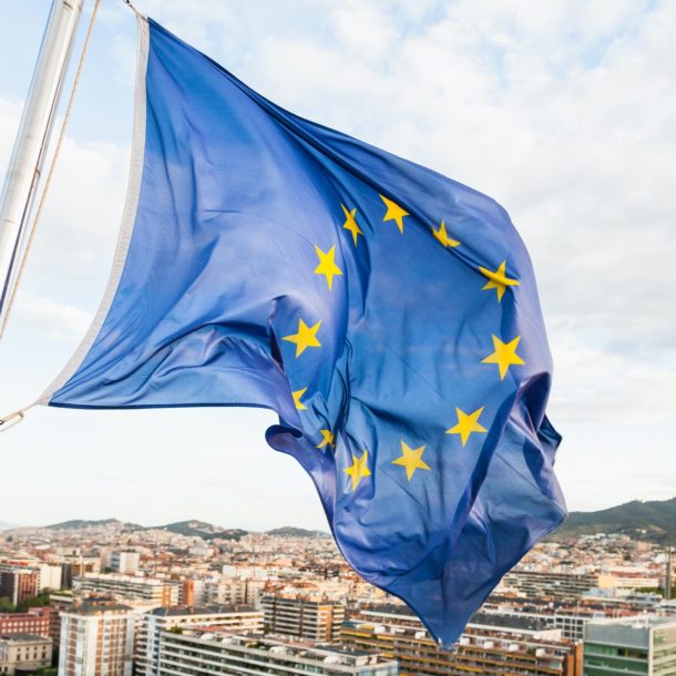 EU flag fluttering by wind above Barcelona