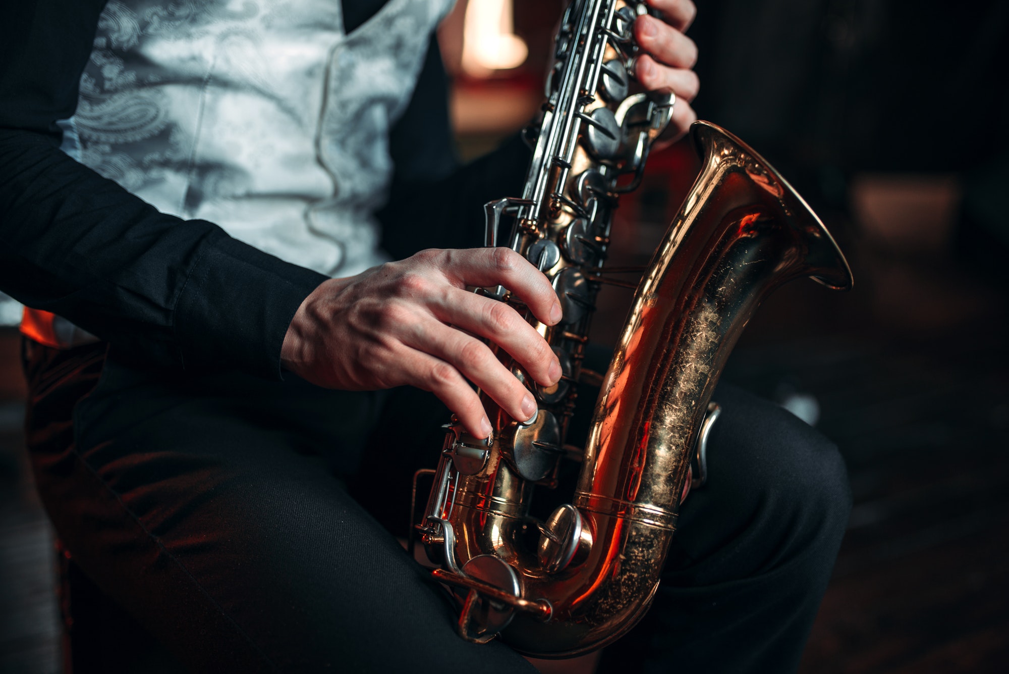 Jazz man hands holding saxophone closeup