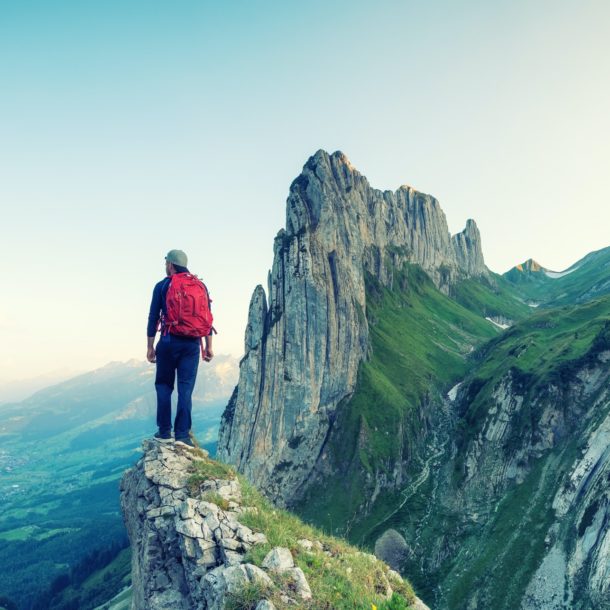 Tourist on a rock in Switzerland. Active rest and tourism in summer time.