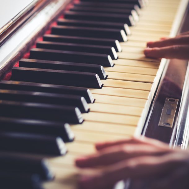 Vintage piano keys and hands playing