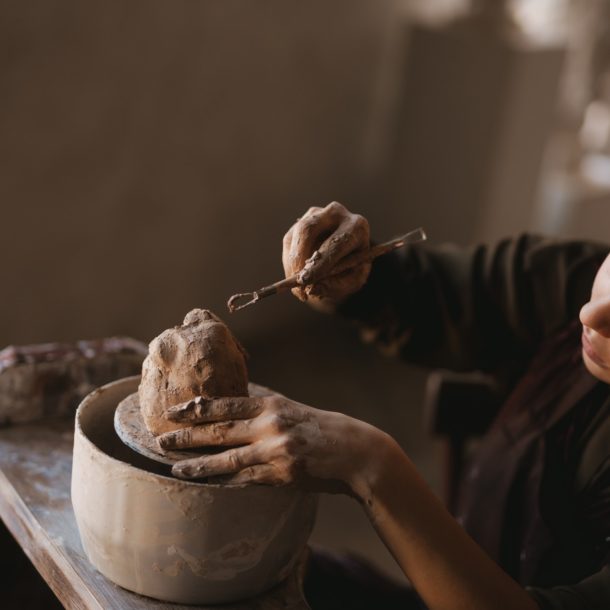 Young woman sculptor artist creating a bust sculpture