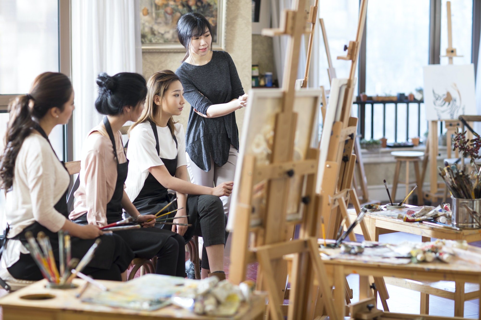 Art teacher with young women in studio