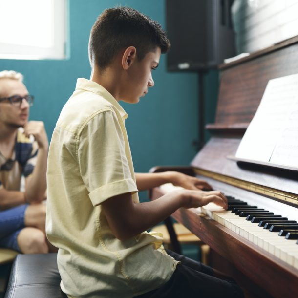 Boy having a piano lesson at music school