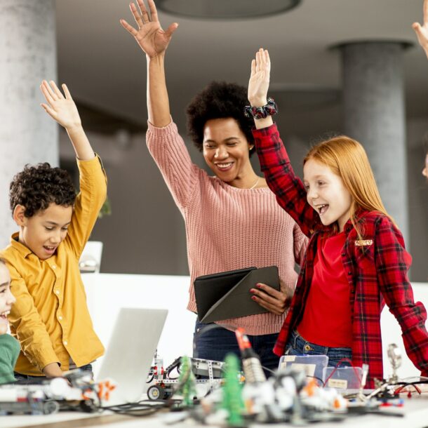 happy kids with their African American female science teacher with laptop