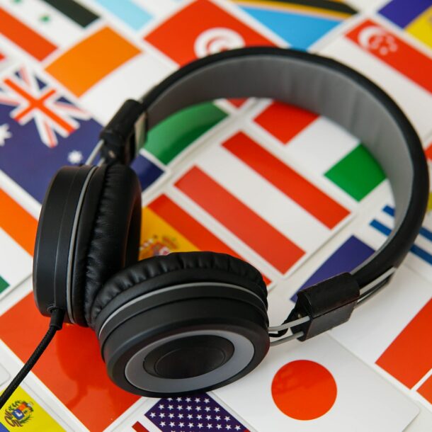 Learning foreign languages online. Headphones and countries flags on the background.