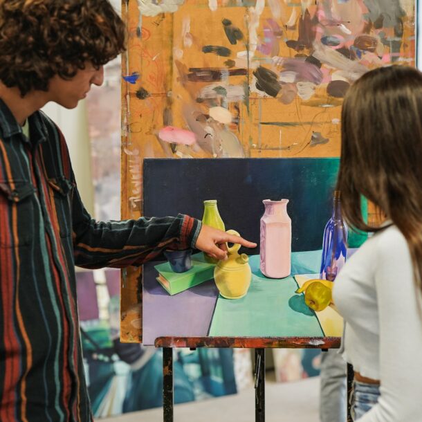 Young university students painting inside art classroom