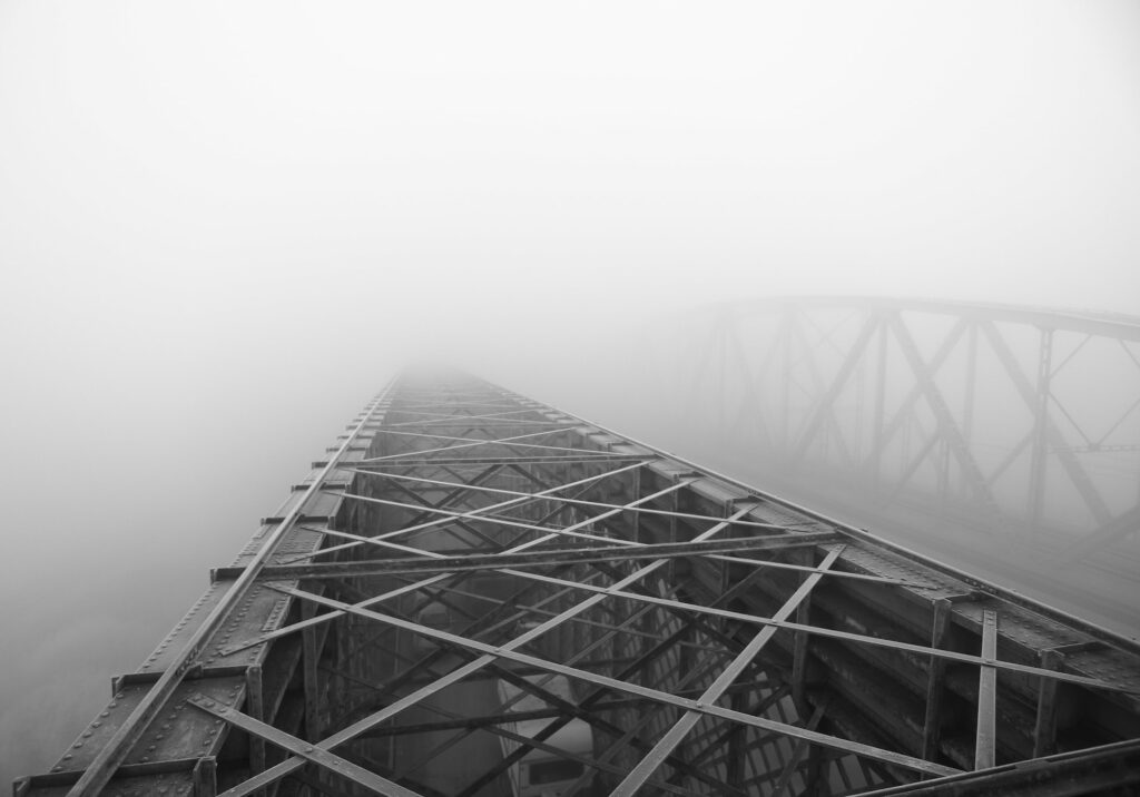 Grayscale shot of an iron construction visible in the foggy air in Tczew, Poland